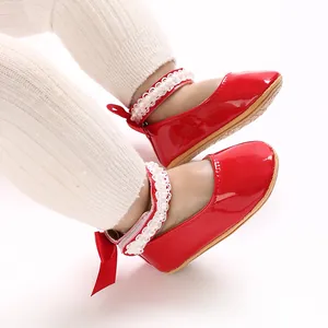 Detailed view of red patent leather baby girl princess shoes with pearl lace straps