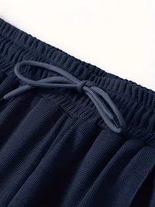 Detailaufnahme der dunkelblauen Sportjacke mit elastischem Kordelzug und Waffelstruktur.