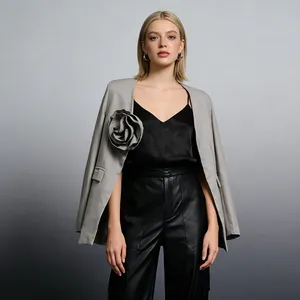 Detail des grauen Blazers mit großer 3D-Blumenverzierung und elegantem Schnitt