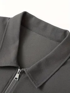 Detailaufnahme der Waffelstruktur und des silbernen Reißverschlusses an der Herrenjacke