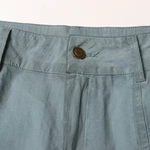 Close-up of high-waisted flared jeans showing bronze button and fabric texture