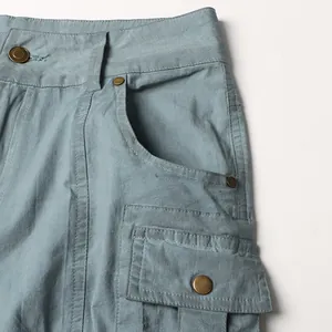 Close-up of high-waist cargo jeans showing pocket detail and metal buttons