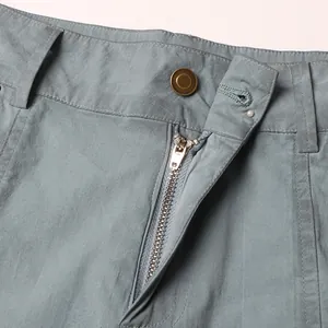 Close-up of high-waist pants showing a durable metal zipper and bronze button