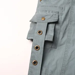Close-up of cargo pocket detail with decorative strap and metal eyelets on light blue flared pants