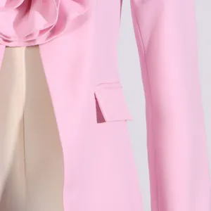 Detailaufnahme von unregelmäßigem Blumendesign an einem rosa Blazer mit Tasche