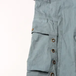 Close-up of utility pocket and metallic grommet detail on stylish high waist trousers