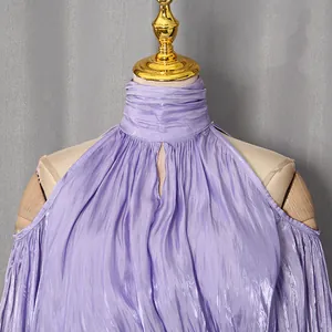 Detailaufnahme eines lila Satin-Halterneck-Oberteils mit elegantem Faltenwurf und Ausschnitten