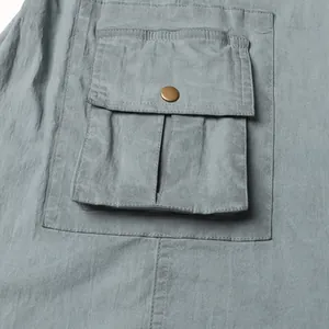 Detail shot of cargo pocket with metal snap button on stylish greyish-blue flared jeans