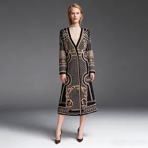Dettaglio di un cappotto lungo di lusso con stampa vintage dorata e ricami di perline
