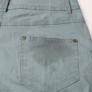 Close-up detail of the back pocket on high waist flare jeans featuring copper rivet accents
