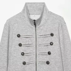 Detailed close-up of a grey jacket featuring decorative military-style silver buttons and zipper