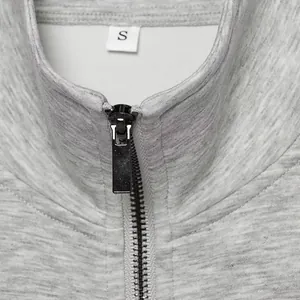 Close-up detail of a grey heather casual jacket collar with black zipper and size S tag