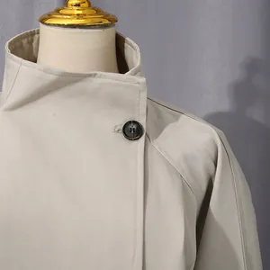 Dettaglio del colletto e del bottone di un trench beige da donna