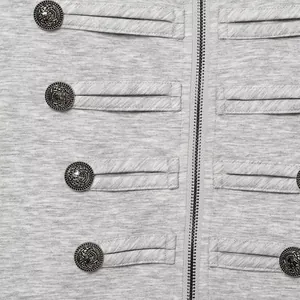Detail showing ornate metal buttons and silver zipper on grey heather fabric jacket