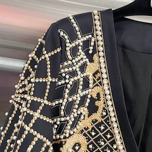 Primo piano di perline e ricami dorati su una lussuosa giacca blazer nera elegante