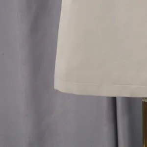 Dettaglio ravvicinato delle cuciture pulite e del tessuto beige di un trench lungo da donna