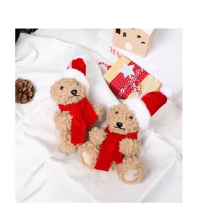 Vue détaillée de peluches d'ours de Noël portant des bonnets de Père Noël et écharpes