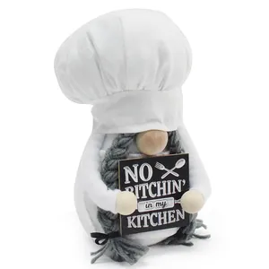 Detailansicht einer Koch-Zwergpuppe, die ein No Bitchin in my Kitchen-Schild in der Hand hält