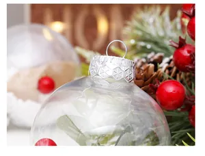 Detalle macro de una bola de Navidad transparente con tapa plateada y follaje interno