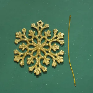 Detailansicht eines goldenen glitzernden Schneeflocken-Ornaments mit Schnur