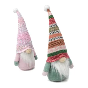 Twee handgemaakte gezichtsloze Scandinavische dwergpoppen in roze en groen decor.