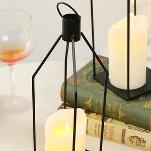 Dettaglio portacandele a lanterna in ferro nero con candela LED su libri vintage