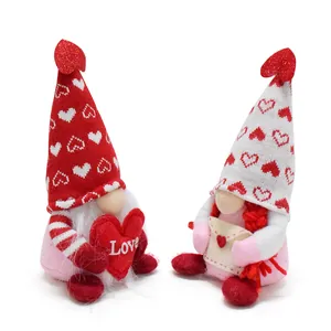 Ein Paar bezaubernde Valentinstag Wichtel, die ein rotes Herz und einen Liebesbrief halten