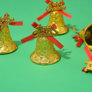 Primer plano de cascabeles navideños dorados con lazos rojos y placas
