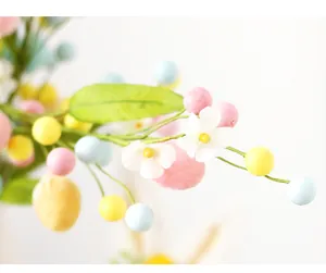 Macro detail of Easter decorative stems with colorful pastel eggs and small white flowers