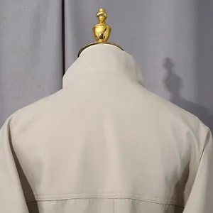 Dettaglio ravvicinato del colletto posteriore e delle cuciture di un trench beige da donna