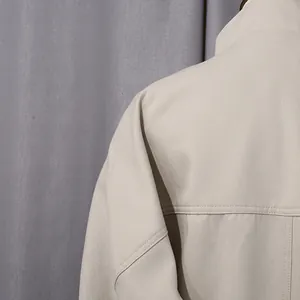 Dettaglio ravvicinato della spalla di un trench beige da donna con cuciture di qualità