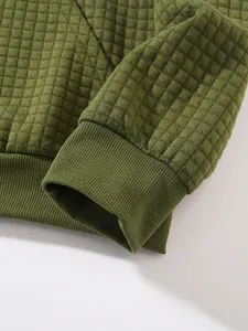 Detailaufnahme der gesteppten Waffelstruktur und der Rippbündchen eines Herren-Sweatshirts