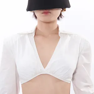Detail of white long-sleeved crop top with elegant V-neck and ruched hem design