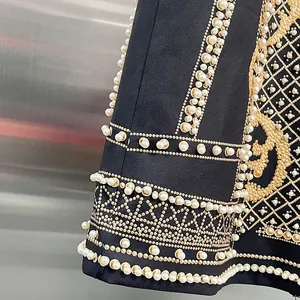 Dettaglio di un blazer di lusso da donna con stampe dorate e decorazioni in perle