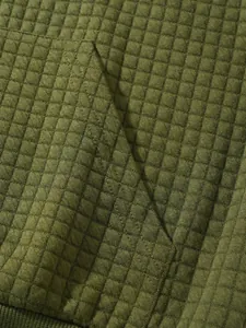 Nahaufnahme der olivgrünen Waffelstrick-Struktur auf dem Sweatshirt mit Taschendetail.