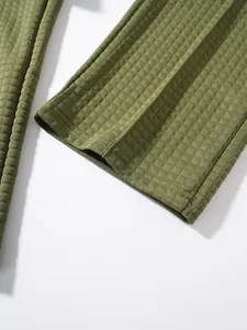 Close-up view showing the intricate olive green waffle knit texture on men's trousers