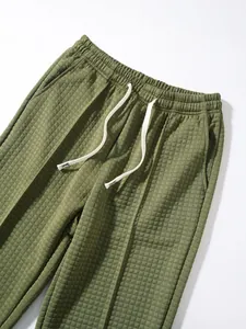 Detail view of olive green waffle knit pants featuring elastic waist and white drawstring