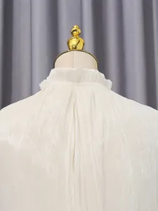 Detailansicht des eleganten Stehkragens mit Rüschen und Plissee-Textur des weißen Kleides