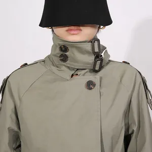Dettaglio del trench kaki in stile francese con colletto regolabile e bottoni tartarugati