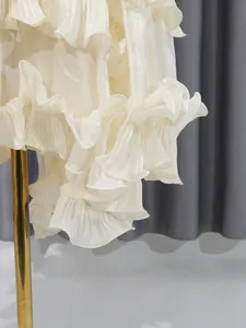 Elegant close-up detail van de gelaagde ruisrand op een witte Franse luxe stijl jurk.