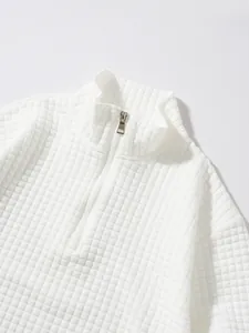Detailansicht der weißen Waffelstrick-Textur bei einem Sweatshirt mit halbem Reißverschluss