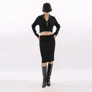 Full body view of an elegant black two-piece set featuring golden safety pin accents
