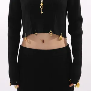 Close-up of black knit cropped top with gold vintage charms and rib texture