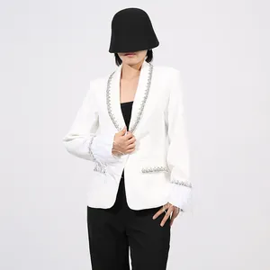 Detailed view of white blazer featuring elegant feather cuffs and shimmering sequin trims.