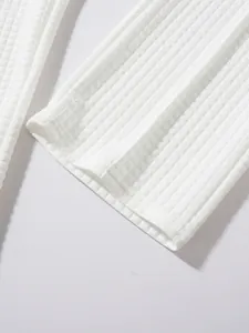 Detailed close-up of white waffle knit fabric texture on the leg opening of men's casual pants