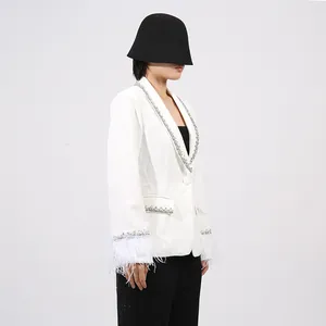 Detailed view of white French style blazer with feather cuffs and rhinestone trim
