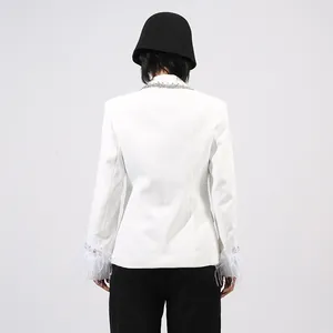 Back view of white blazer featuring elegant feather cuffs and embellished collar detail