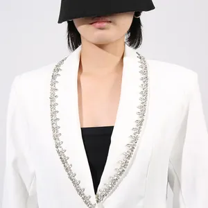 Detail view of a white French-style blazer with sparkling rhinestone lapel trim