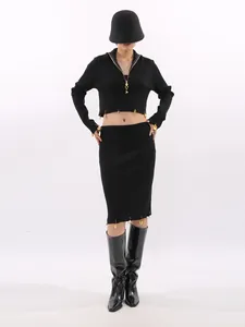 Elegant black two-piece set with cropped top and midi skirt featuring gold pin accents