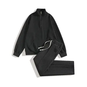 Close-up of black waffle knit texture on men's half-zip sweatshirt and pants set